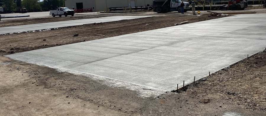 Large finished concrete slab across an open commercial site.