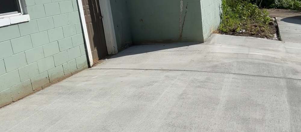 Finished concrete driveway running from a garage toward the street.